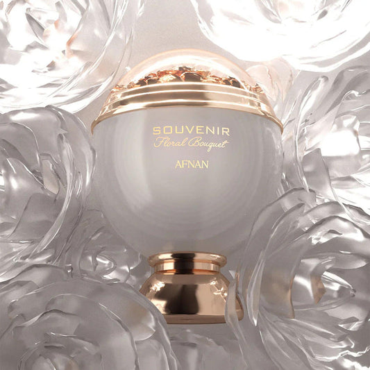 Afnan Souvenir Floral Bouquet Eau De Parfum elegant white and gold spherical bottle surrounded by translucent floral decorations under soft lighting