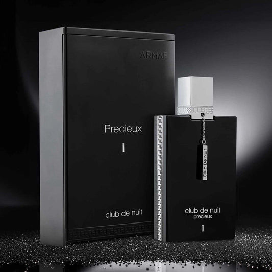 Armaf Club De Nuit Precieux I Eau De Parfum black bottle with silver cap and chain displayed beside its matching black packaging on a reflective surface