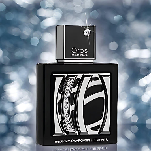Oros Eau De Toilette perfume bottle with Swarovski crystal detailing in black and silver design displayed against a sparkling blue bokeh background