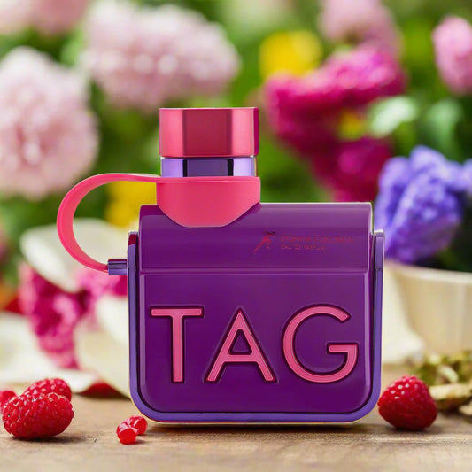 Armaf Tag Donna Colorata Eau De Parfum vibrant purple and pink bottle displayed on a wooden surface with raspberries and colorful flowers in the background