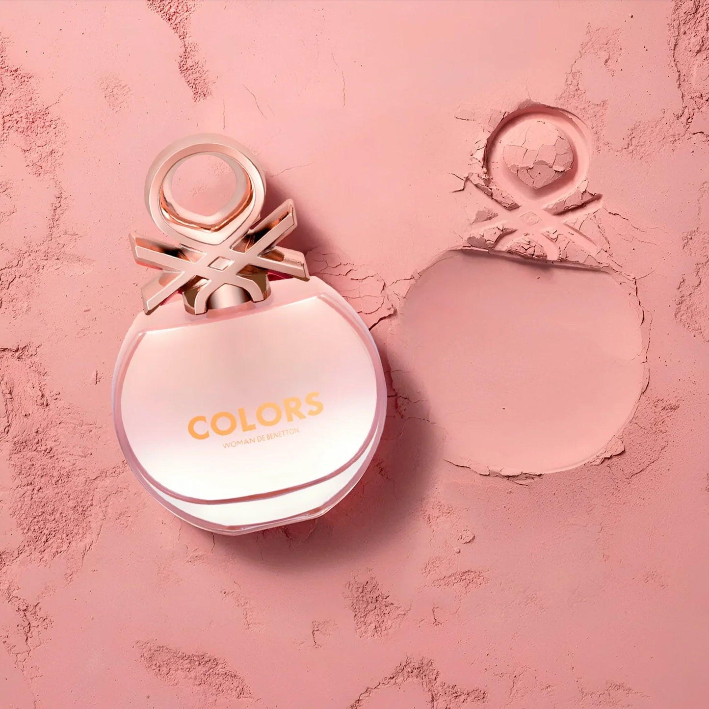 United Colors of Benetton Colors Woman Eau De Toilette bottle placed on a soft pink textured surface with its elegant imprint beside it, highlighting its feminine and playful design