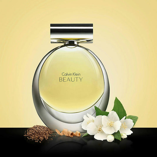 Calvin Klein Beauty Eau De Parfum elegant round bottle with white jasmine flowers and seeds on a yellow background