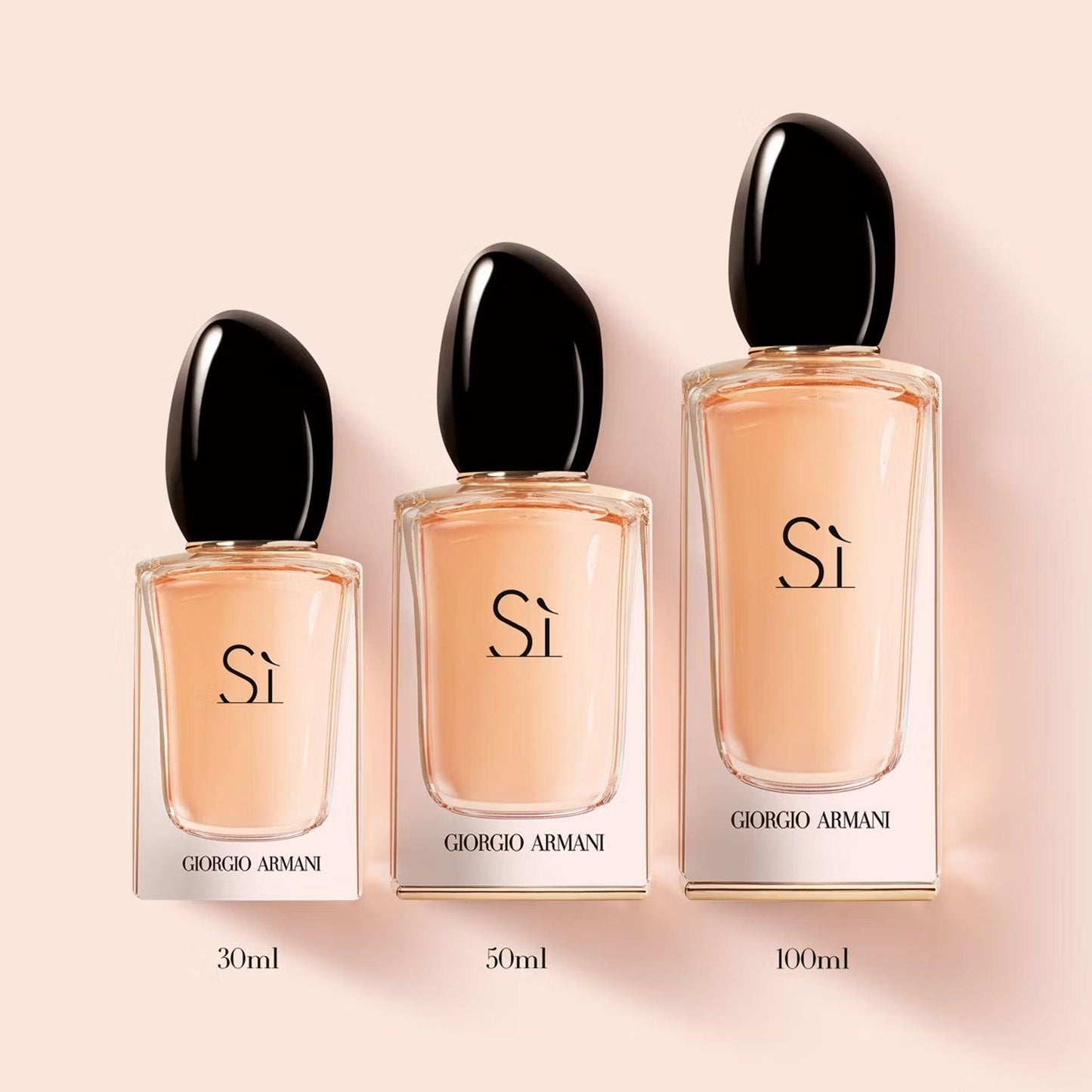 Giorgio Armani Si Eau De Parfum bottles in three sizes 30ml, 50ml, and 100ml displayed on a soft beige background with elegant black caps and peach-toned liquid