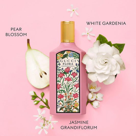 Gucci Flora Gorgeous Gardenia bottle with floral design on pink background with gardenia and jasmine.