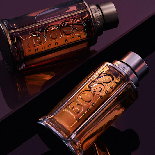 Hugo Boss The Scent Absolute Eau De Parfum bottles for men displayed on a glossy dark surface, highlighting their amber tones and elegant design.
