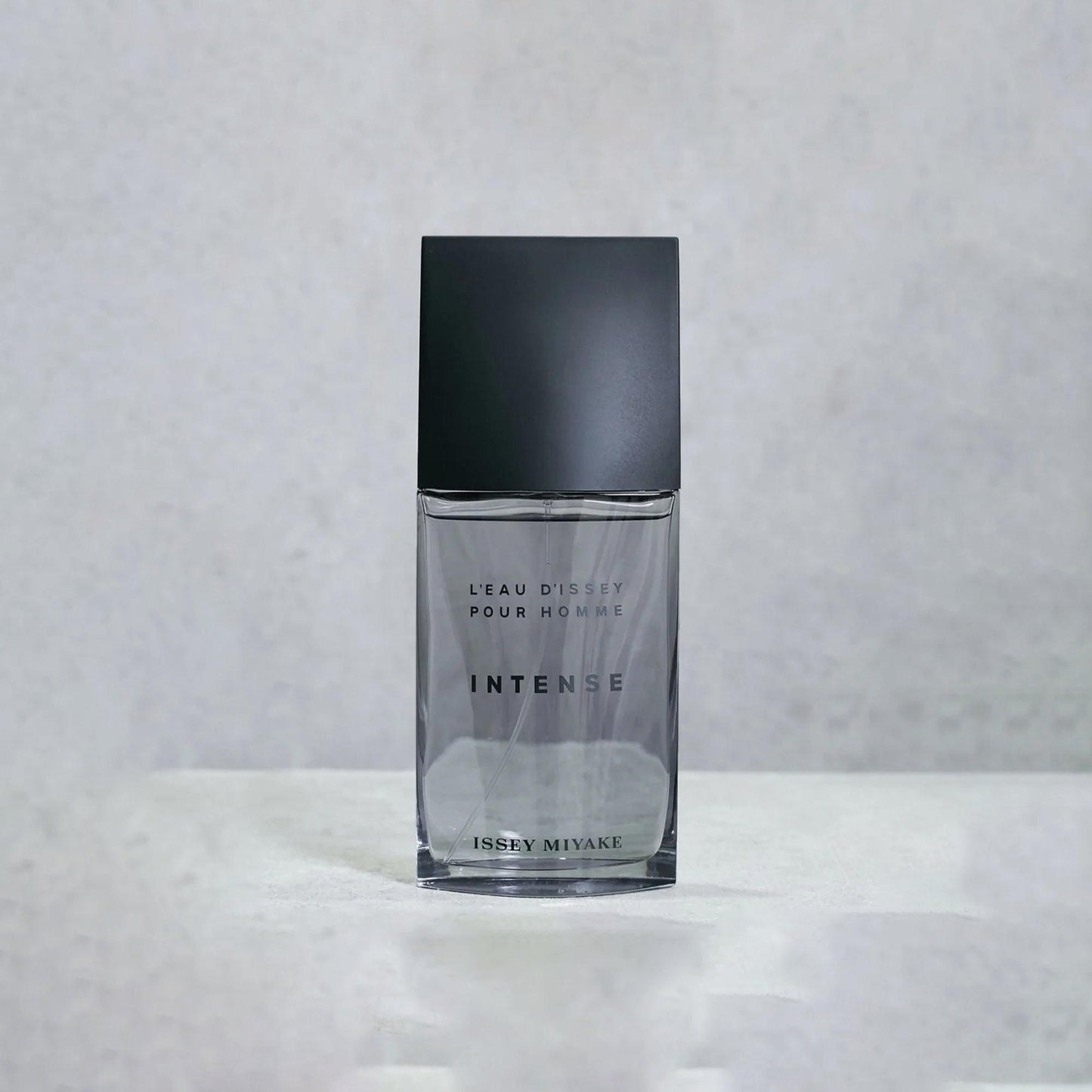 Issey Miyake L’Eau D’Issey Pour Homme Intense Eau De Toilette bottle in sleek black and transparent design placed on a light grey surface