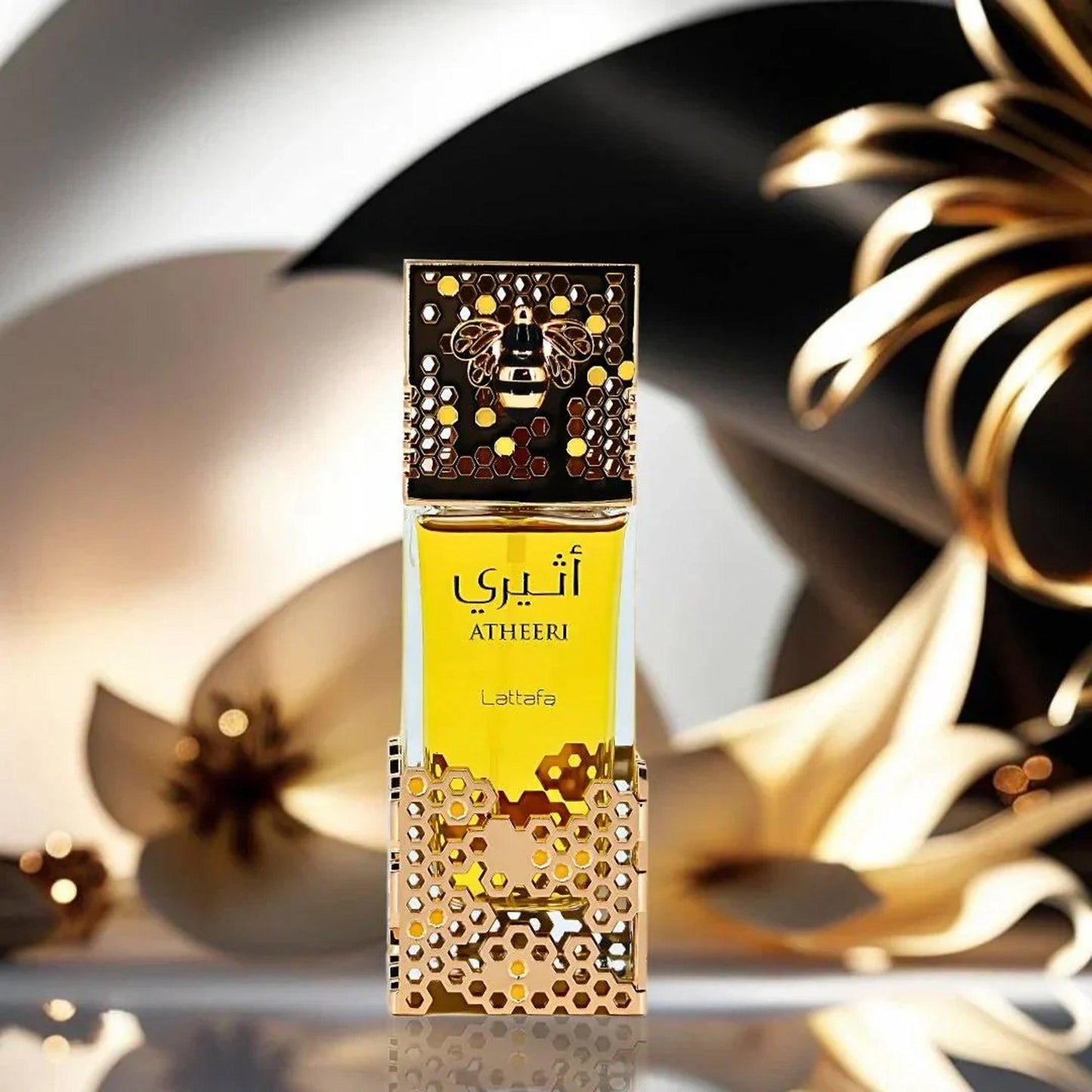 Lattafa Atheeri Eau De Parfum golden bottle with honeycomb design and bee emblem cap placed against a luxurious gold and cream abstract background