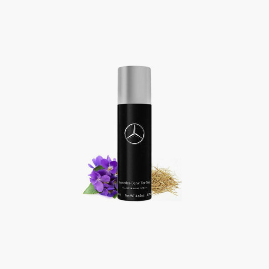 Mercedes-Benz For Men body spray in a sleek black bottle with silver cap displayed on a white background alongside purple flowers and dry grass