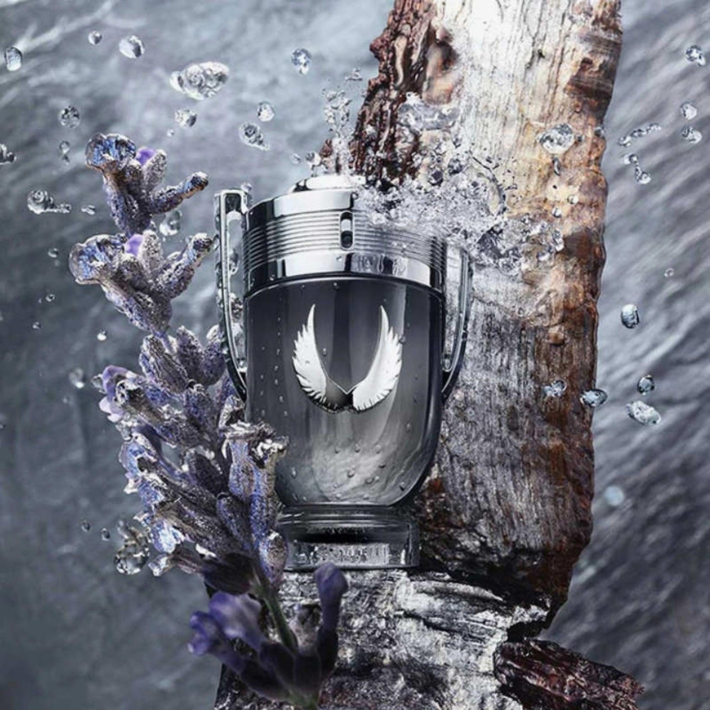 Paco Rabanne Invictus Victory Elixir Eau De Parfum trophy-shaped bottle placed beside lavender flowers and wood, surrounded by splashing water for a fresh and woody look