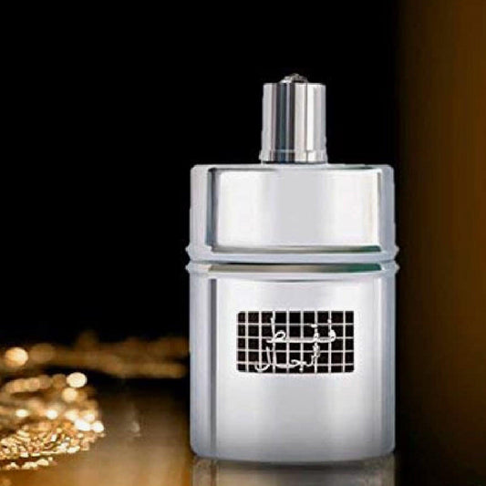 Rasasi Fattan Eau De Parfum silver bottle displayed against a dark black background with golden reflections on the surface.
