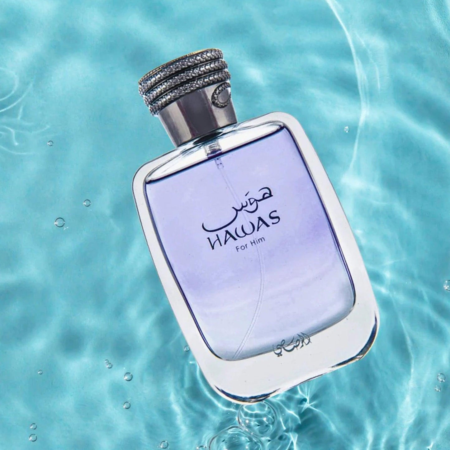 Rasasi Hawas For Him perfume bottle with light purple liquid floating over clear blue water, reflecting freshness and aquatic elegance for men