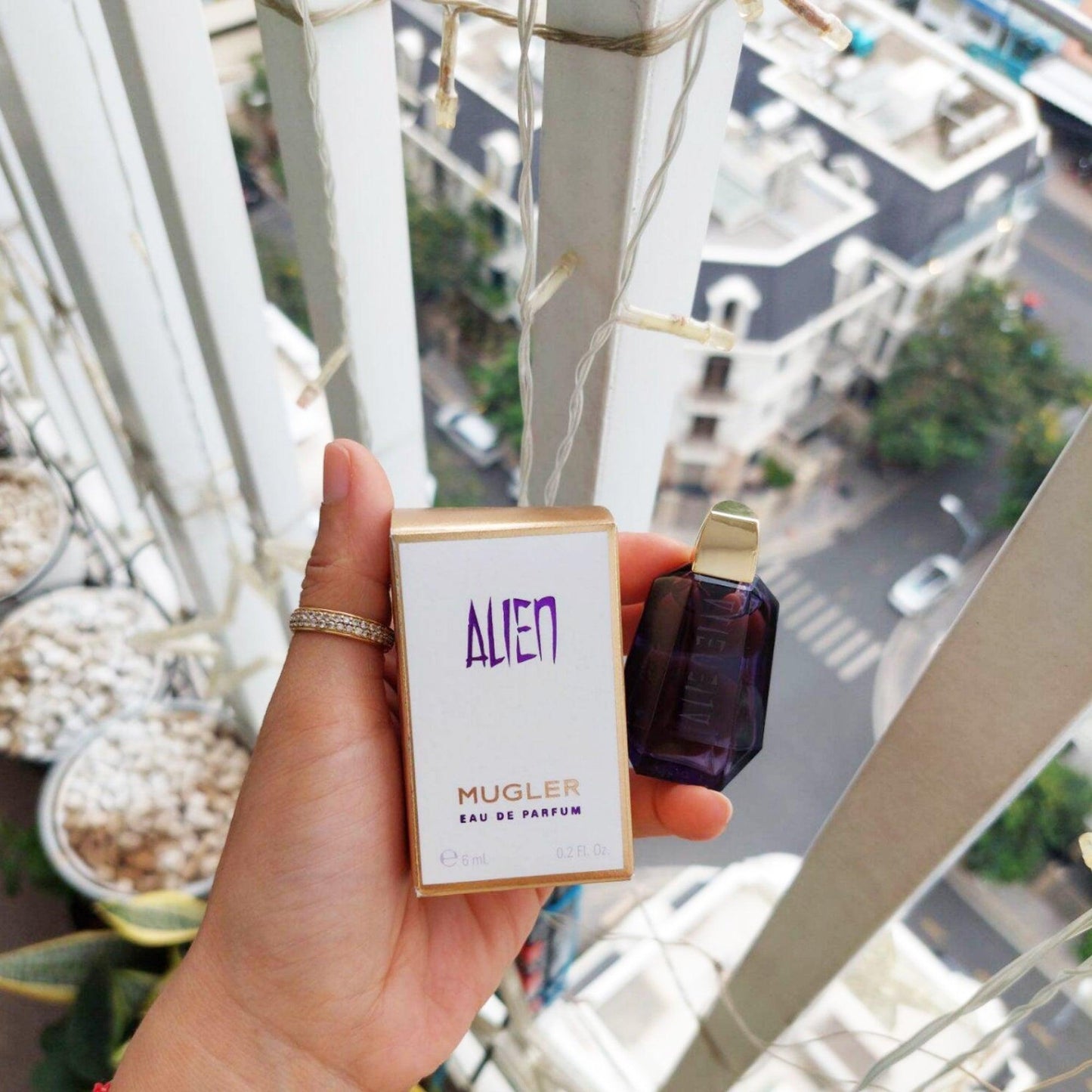 Mugler Thierry Alien perfume bottle and packaging with city view