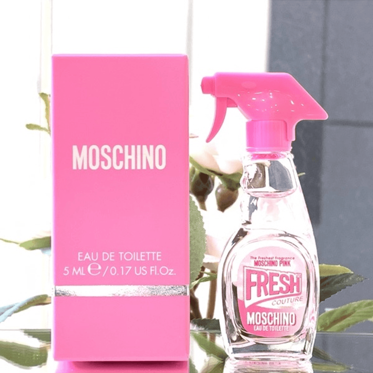 Moschino Pink Fresh Couture Eau De Toilette 5ml miniature bottle with spray-gun style pink cap placed beside its bright pink packaging box