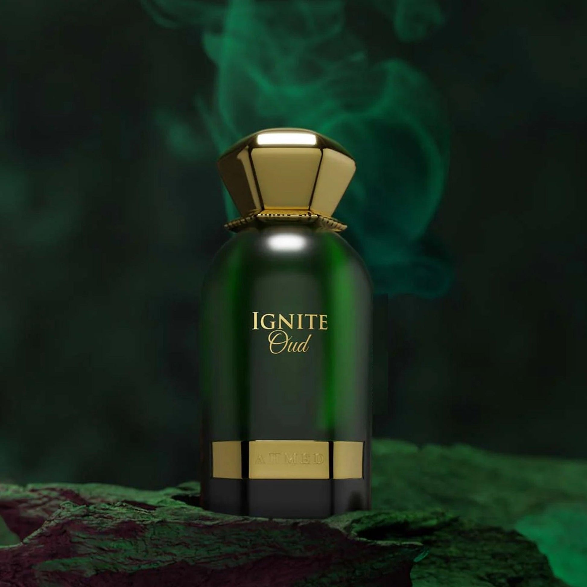 Ahmed Ignite Oud Eau De Parfum in a deep green bottle with a gold cap, placed on a textured dark surface with green smoke rising in the background for a bold and luxurious visual