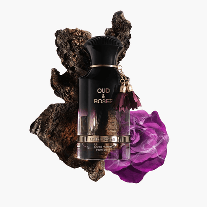 Ahmed Al Maghribi Oud & Roses Eau De Parfum 60ml bottle with black and gold design placed on oud wood and a purple rose for an elegant presentation