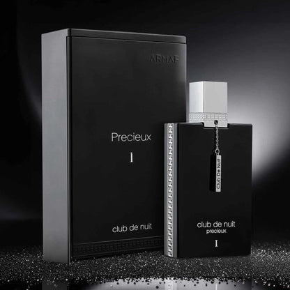 Armaf Club De Nuit Precieux I Eau De Parfum black bottle with silver cap and chain displayed beside its matching black packaging on a reflective surface