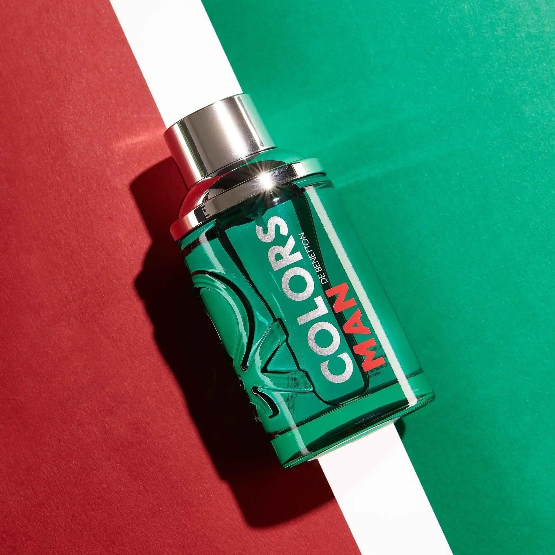 United Colors of Benetton Colors Man perfume bottle in vibrant green with bold red text, placed on a stylish red and green background for a dynamic, modern aesthetic