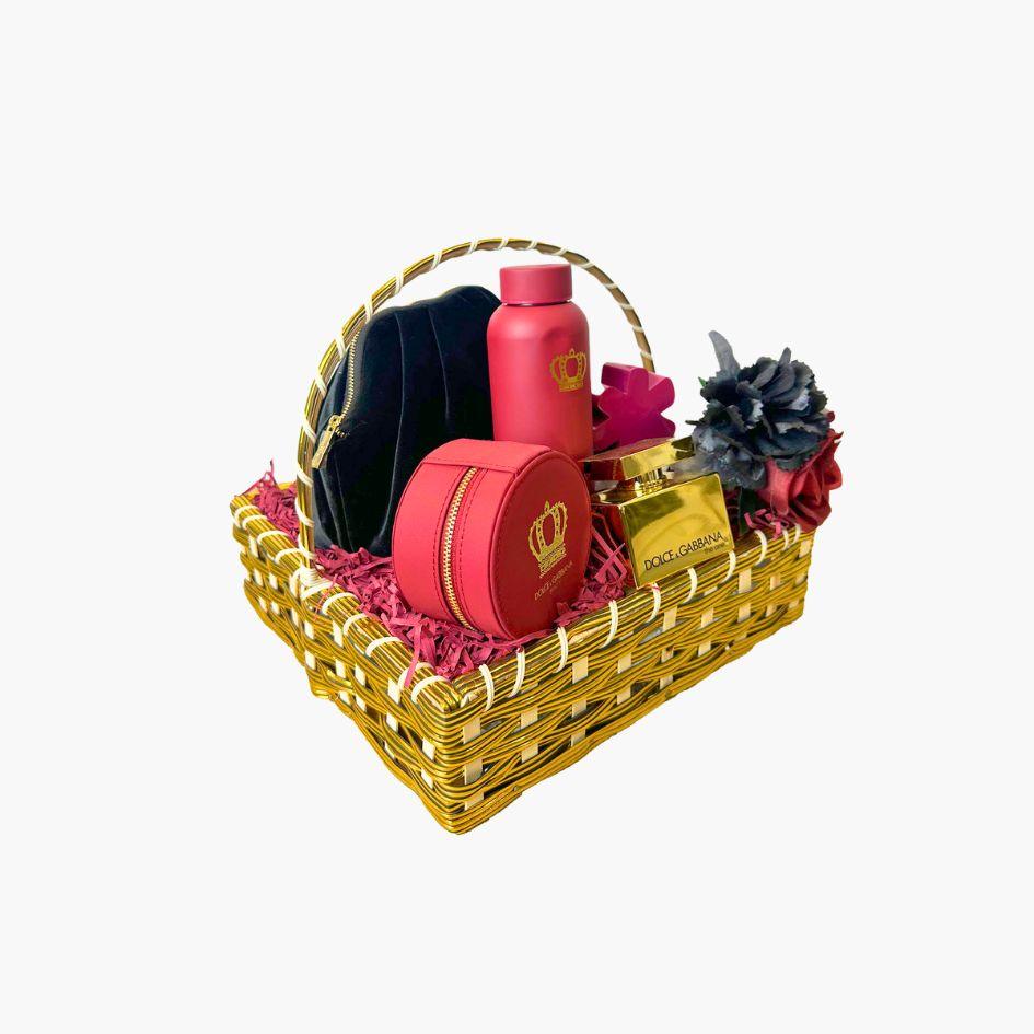 Dolce & Gabbana luxury gift basket with red perfume, lotion, black pouch, and gold fragrance bottle surrounded by red and black flowers