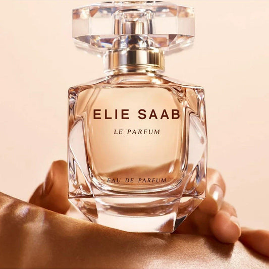 Elie Saab Le Parfum bottle with a crystal-style cap and golden nude fragrance held gracefully against a soft beige background