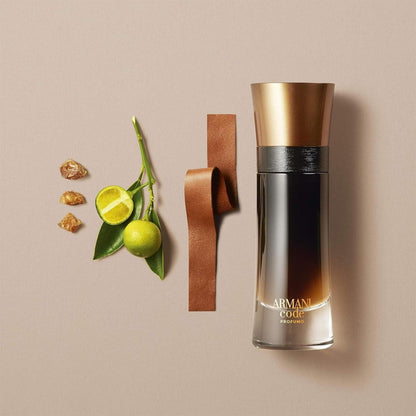 Giorgio Armani Code Profumo Eau De Parfum bottle placed beside lime, amber resin, and a strip of brown leather on a beige background.