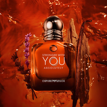 Emporio Armani Stronger With You Absolutely Eau De Parfum amber-brown bottle surrounded by lavender, wood, and amber tones with a rich golden liquid background