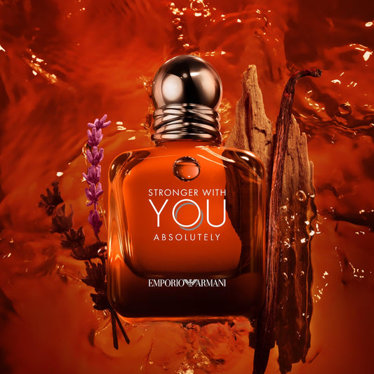 Emporio Armani Stronger With You Absolutely Eau De Parfum amber-brown bottle surrounded by lavender, wood, and amber tones with a rich golden liquid background