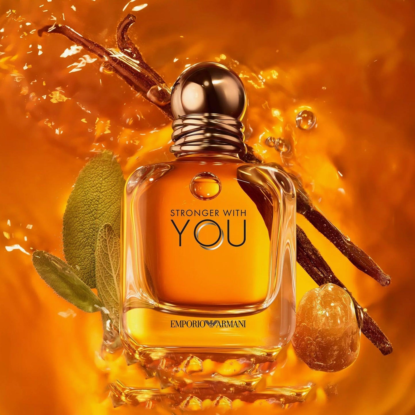 Emporio Armani Stronger With You Eau De Toilette amber-colored perfume bottle surrounded by vanilla sticks, sage leaves, and warm golden liquid background