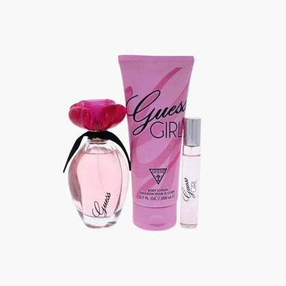 Guess Girl fragrance set with pink Eau De Toilette bottle, body lotion, and rollerball, featuring a floral cap