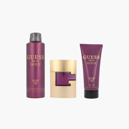 Guess Man Gold fragrance gift set featuring a gold and purple bottle of Guess Man Gold Eau de Toilette, a matching deodorizing body spray, and a body lotion, all packaged in a purple and gold box.