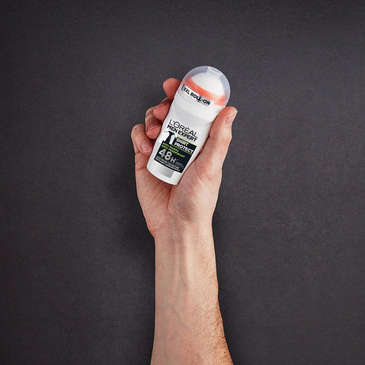 A hand holding L’Oreal Men Expert Shirt Protect 48H roll-on deodorant against a dark background, showcasing its sleek white and black packaging designed for long-lasting freshness