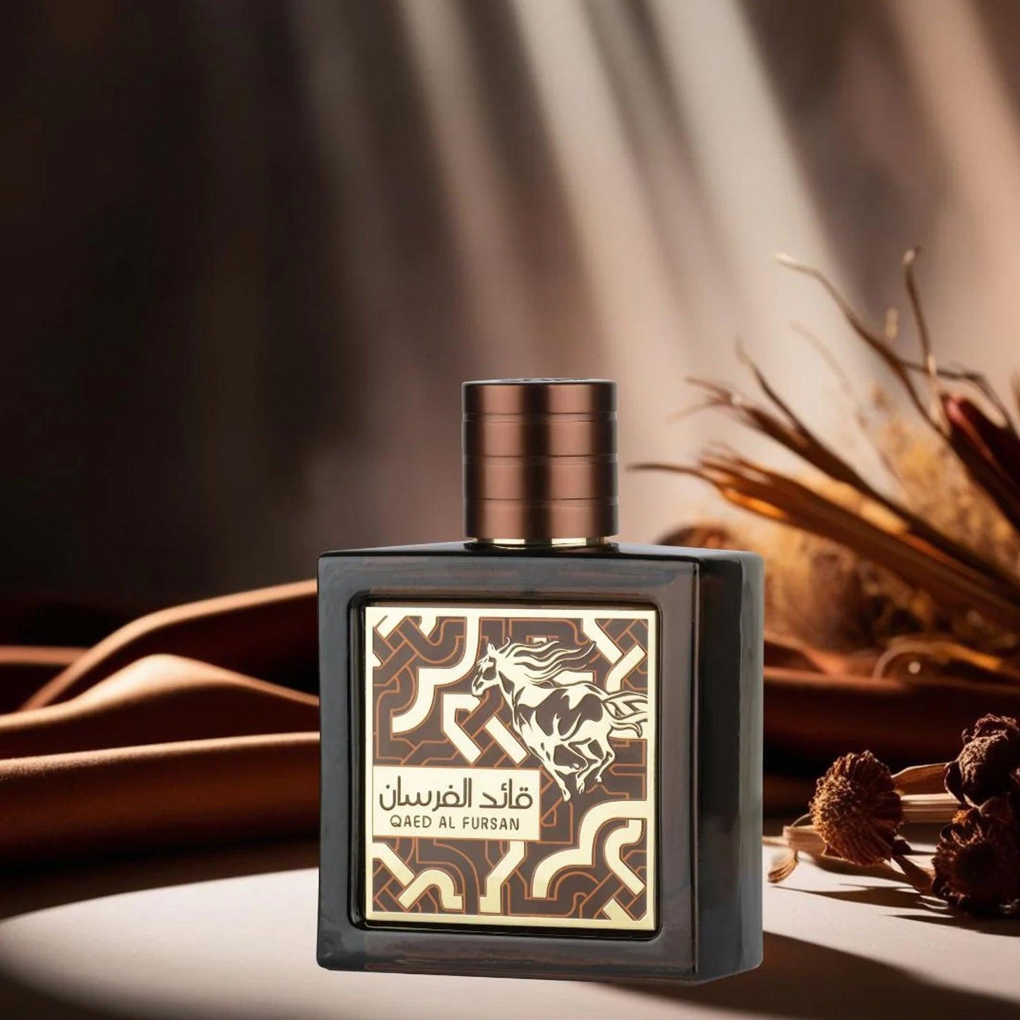 Lattafa Qaed Al Fursan Eau De Parfum dark brown bottle with golden horse design placed on a soft brown fabric surface with dried flowers and warm lighting