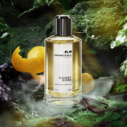 Mancera Cedrat Boise Eau De Parfum 120ml bottle placed in a lush green forest setting with citrus peels and vanilla pods, highlighting its fresh and woody fragrance theme.