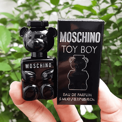 Moschino Toy Boy Eau De Parfum mini black teddy bear-shaped bottle held by hand beside its sleek black packaging box with silver logo