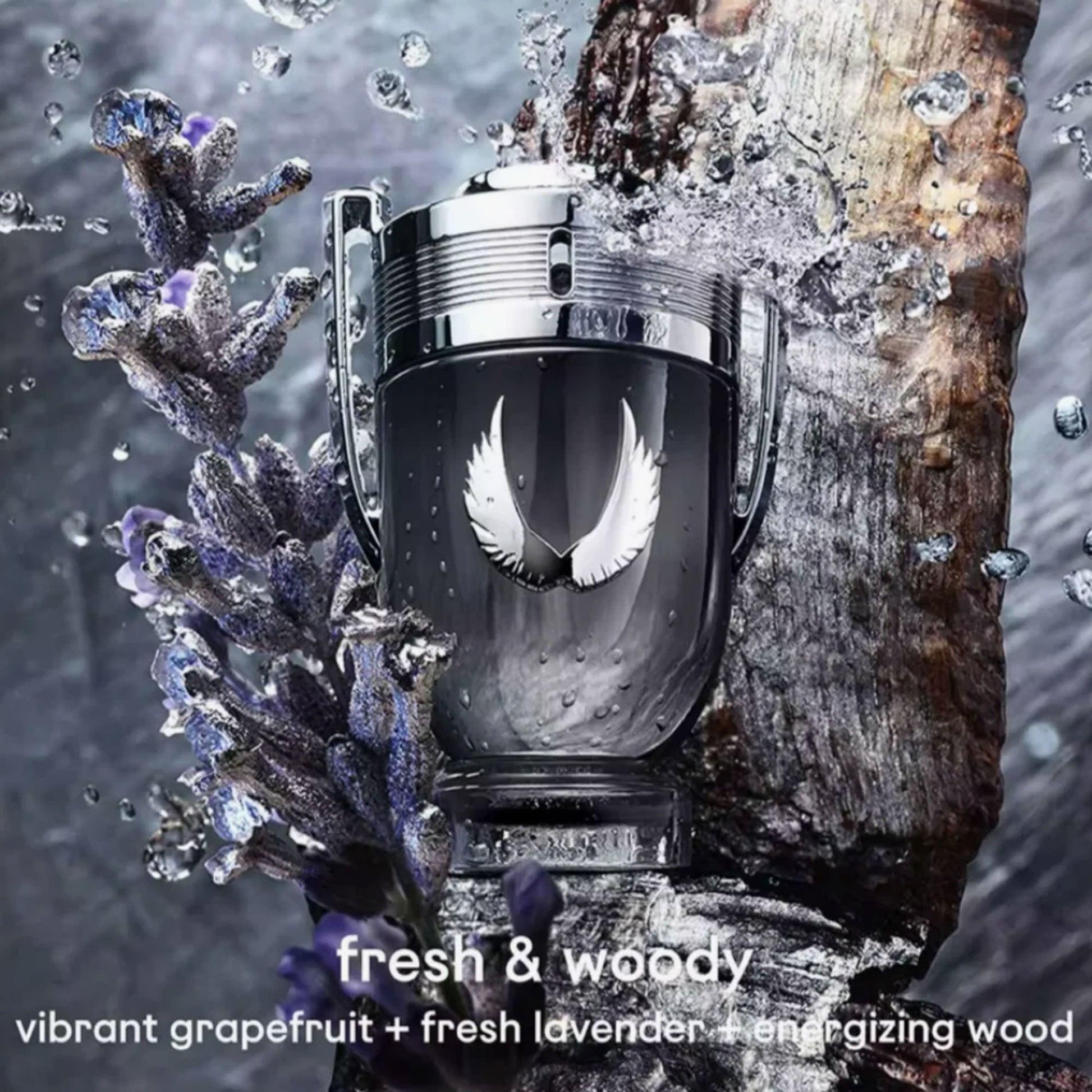 Paco Rabanne Invictus Victory Elixir Eau De Parfum trophy-shaped bottle surrounded by splashing water, lavender flowers, and wood textures creating a fresh and woody atmosphere