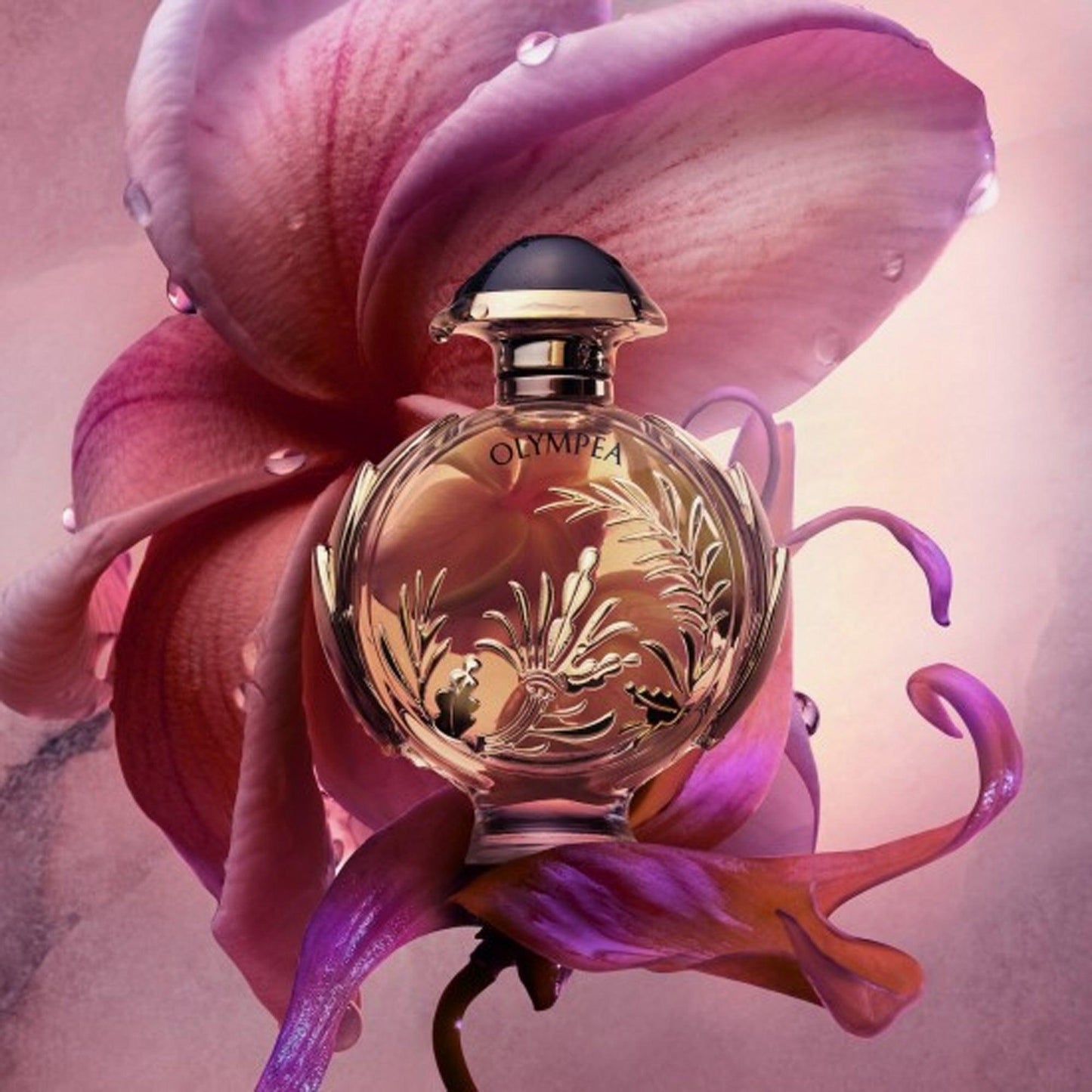 Paco Rabanne Olympea Flora Eau De Parfum elegant round bottle with gold floral design surrounded by pink and purple orchid petals on a soft, dewy background
