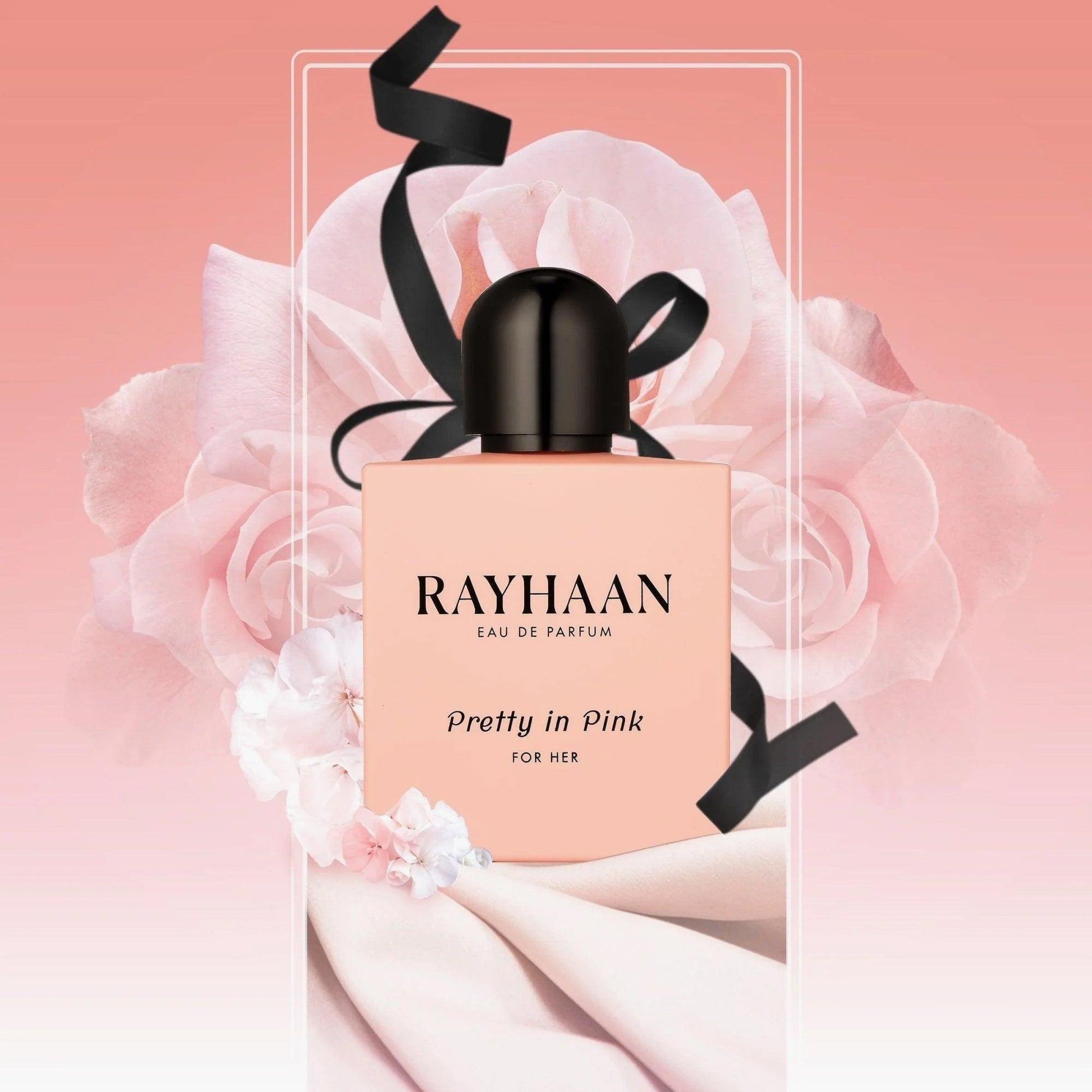 Rayhaan Pretty in Pink For Her Eau De Parfum bottle with black ribbon detailing, placed against a soft pink floral background with roses