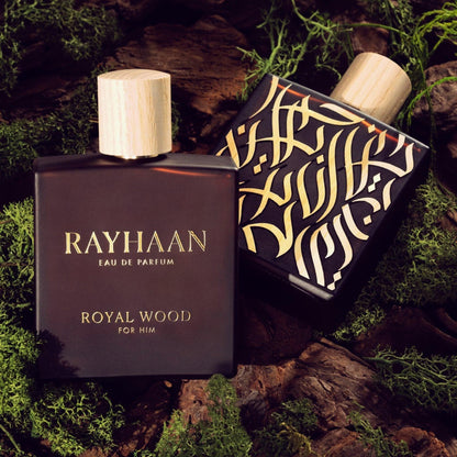 Rayhaan Royal Wood For Him Eau De Parfum bottles with gold detailing and wooden caps placed on moss and bark background representing a woody theme