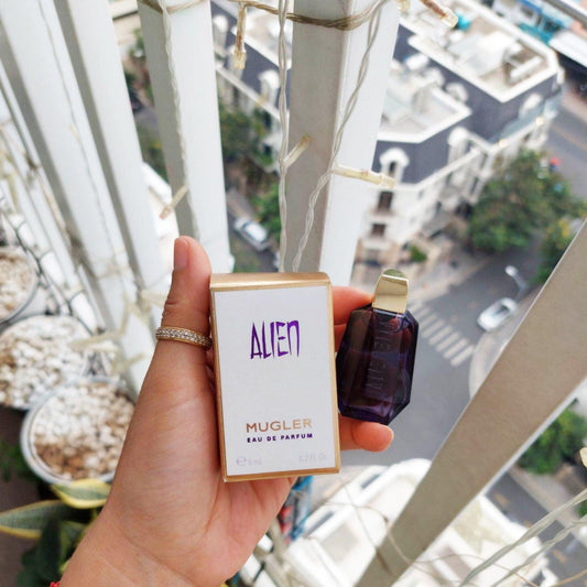 Mugler Thierry Alien perfume bottle and packaging with city view