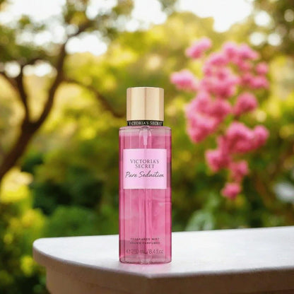 Victorias Secret Pure Seduction body mist with pink flowers and trees in background