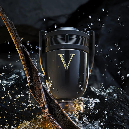 Paco Rabanne Invictus Victory Eau De Parfum trophy-shaped black bottle with gold V logo surrounded by splashing water and dark wooden elements